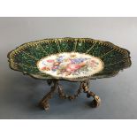 An enamelled dish with painted floral design to centre on ormolu base, height 11cm, length 26cm.