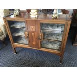An early twentieth century mahogany arts and craft glazed two door display cabinet with inlay