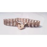 A yellow gold gate bracelet with safety chain, hallmarked 375, approx. weight 10.3gms. IMPORTANT: