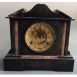 A black slate classical temple style mantel clock with mottled red marble detail and brass face,