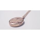An oval rose gold and yellow gold patterned locket, marked 375 on link yellow metal chain, approx.