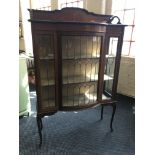 A turn of the century mahogany bow fronted display cabinet with inlay decoration and lead glazed