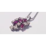 A ruby and diamond cluster pendant marked 750, on a chain marked 9k, approx. length of chain 15",