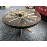 An oak coffee table in the form of a cart wheel with glass top. IMPORTANT: Online viewing and