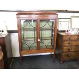 An early 20th century mahogany glazed two door display cabinet with swag inlay decoration and