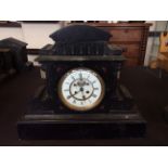 A black slate classical temple design mantel clock with red marble inlay and engraved detail, height