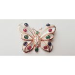 A yellow gold marked 18k butterfly style brooch with emeralds, rubies, sapphires on wings, body