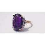 A yellow gold marked 750, amethyst and diamond cluster ring, with five small diamonds either side of