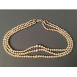 A three row string of pearls, 'Ledawn' with gem stone clasp marked sterling silver. IMPORTANT: