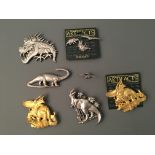 Five dinosaur Jonette Jewelry pin brooches and four badges. IMPORTANT: Online viewing and bidding