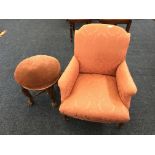 A pink upholstered chair with an oak four leg stool with claw and ball feet.