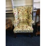 A floral pattern wing backed fireside armchair.