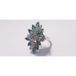 A white metal emerald and diamond dress ring, with twelve diamonds and ten emeralds, ring size L 1/