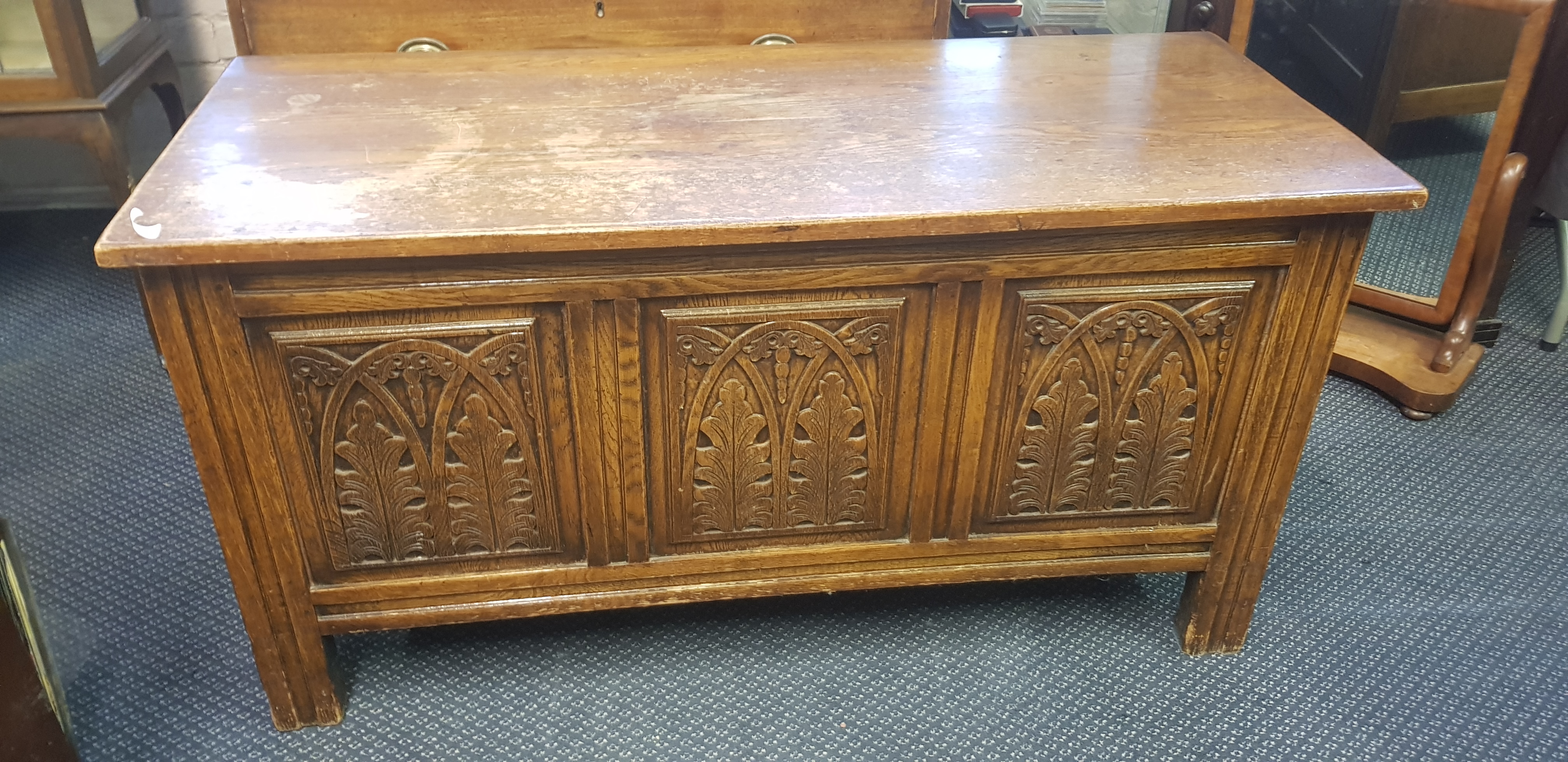 A Thomas Clarkson & Son oak blanket box with three Gothic style panels to front. IMPORTANT: Online