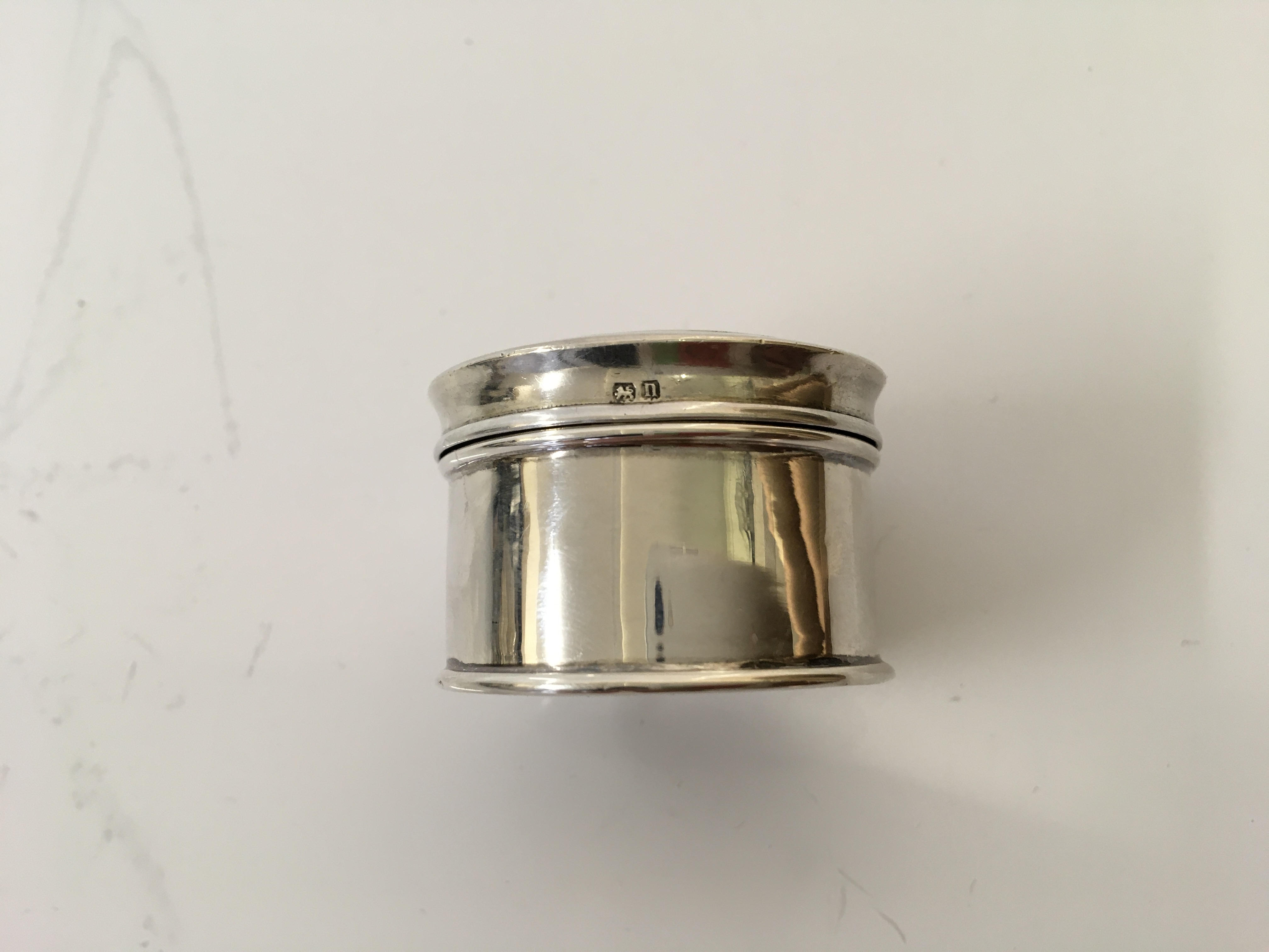 A small silver circular compact