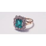 A yellow gold emerald and diamond square cluster ring, marked 750 , 12 diamonds surrounding emerald,