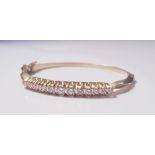 A yellow metal and diamond bangle, 13 diamonds to bangle, approx. weight 21gms. On line viewing