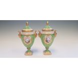 A pair of Coalport lidded vases, shape number Min 130 and decorated with oval vignettes of landscape