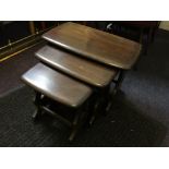 A nest of three dark stained Ercol tables, with four Ercol chairs, kitchen dresser and table.