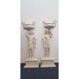 A pair of early to mid 20th century carved wood blackamoor stands holding Phoenix decorated uns