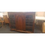 A mahogany book case with two glazed doors and one central cupboard door. IMPORTANT: Online