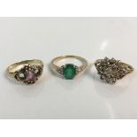 Three 9ct yellow gold rings stamped 375, one with central emerald and three diamonds to each side,