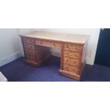 A Victorian birds eye maple nine drawer desk with black ebony inlay and leather insert top.