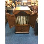 An oak record cabinet with a quantity of various records in it. IMPORTANT: Online viewing and
