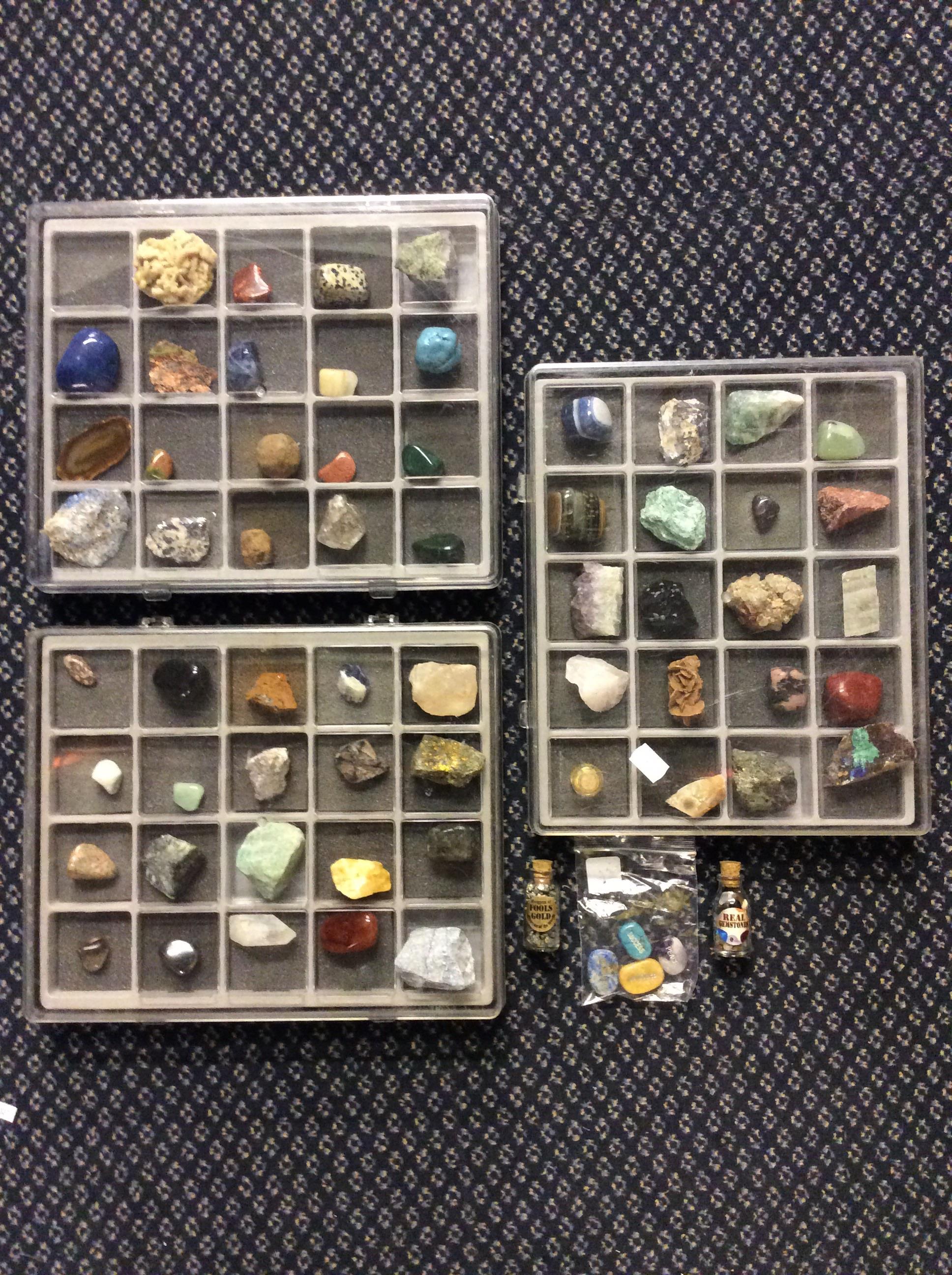 A collection of approximately 61 various gemstones in three cases with two bottles of additional