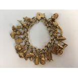 A 9ct yellow gold charm bracelet stamped 375 with 17 various charms, approx. weight 67.9gms.