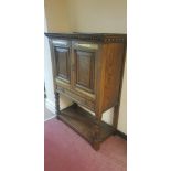 A John Taylor & Son Edinburgh oak two door cabinet with single drawer below on square carved legs to