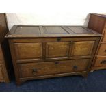 An oak three panelled mule chest with single drawer to base and lion face drop handles. IMPORTANT: