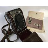 A Rolleiflex T2133532 camera with user manual.