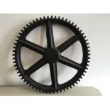 A black painted wooden cog wheel marked ‘SG693 65’. IMPORTANT: Online viewing and bidding only.