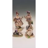 Four German figurines including two Dresden, couple by tree and man holding bird, together with