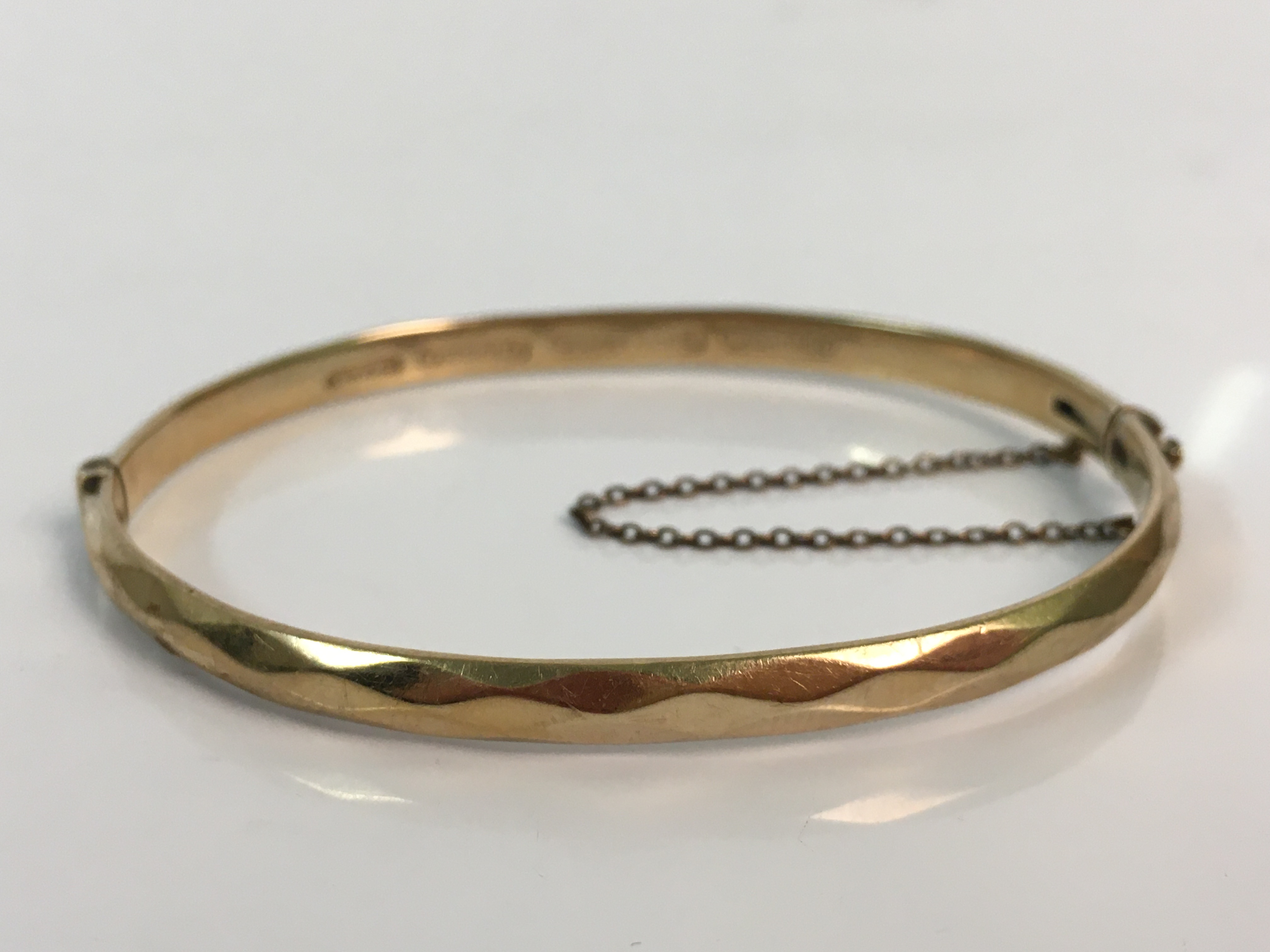 A 9ct yellow gold bangle with silver core, approx. weight 14.6gms. Online viewing and bidding