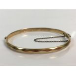 A 9ct yellow gold bangle with silver core, approx. weight 14.6gms. Online viewing and bidding