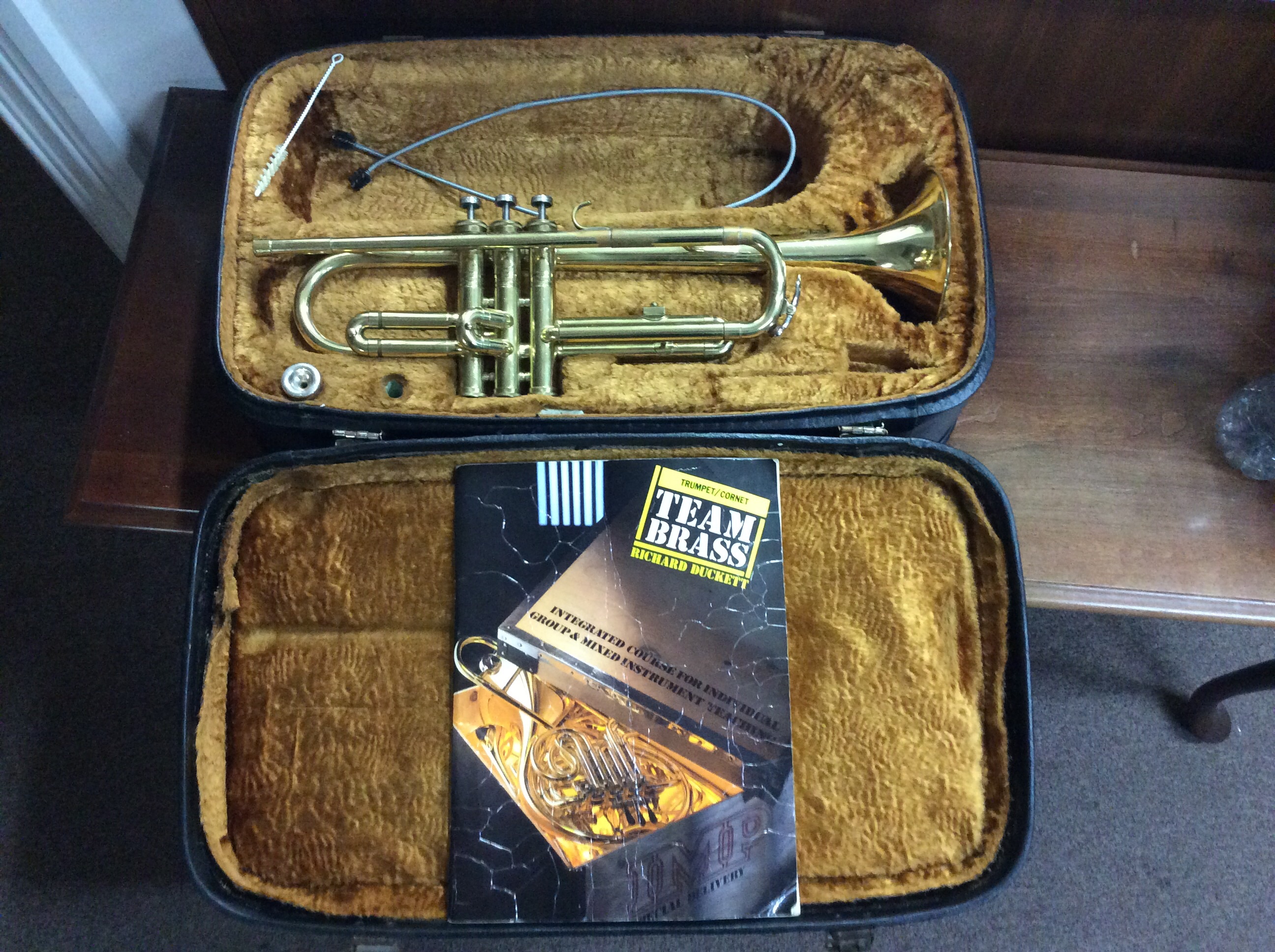 A trumpet in fitted box with teaching book. IMPORTANT: Online viewing and bidding only. No in person