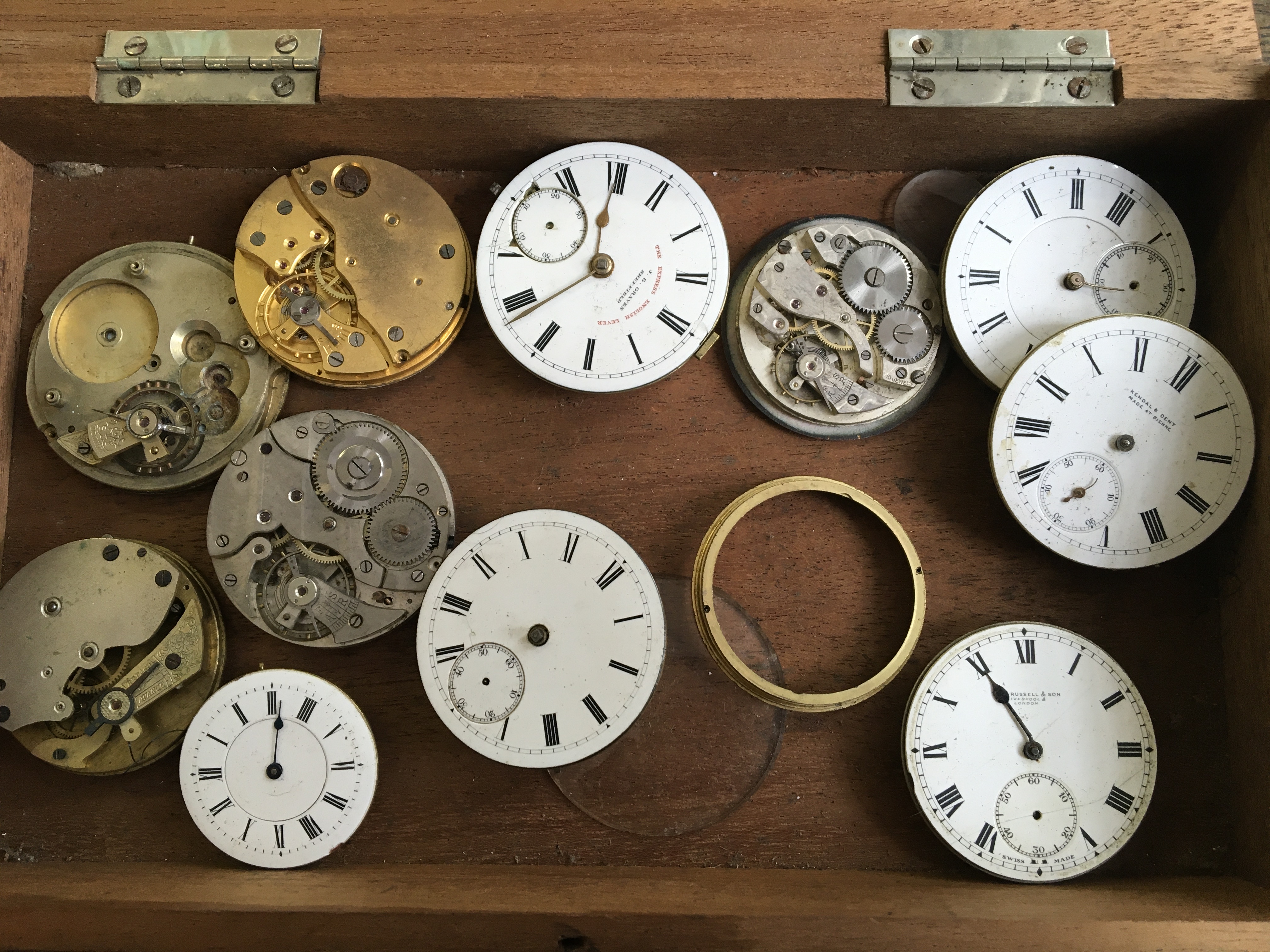 A box containing watch faces and other parts including Russell & Son, J.G. Graves, etc. Online