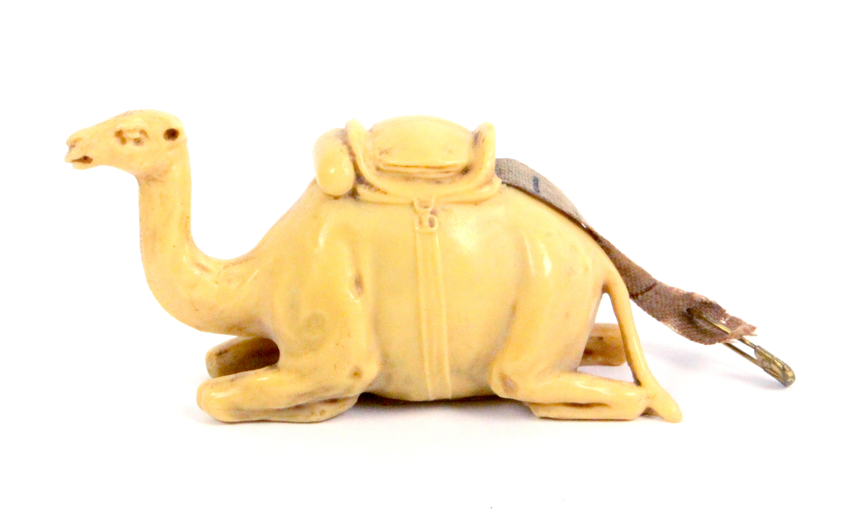 A celluloid novelty tape measure in the form of a seated camel, complete retractable printed tape,