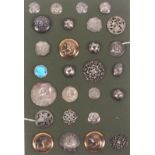 Buttons - a card display of twenty seven mostly silver examples including a set of five with heart