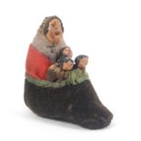 A novelty pin cushion 'There was an old woman who lived in her shoe', the old woman in shawl and