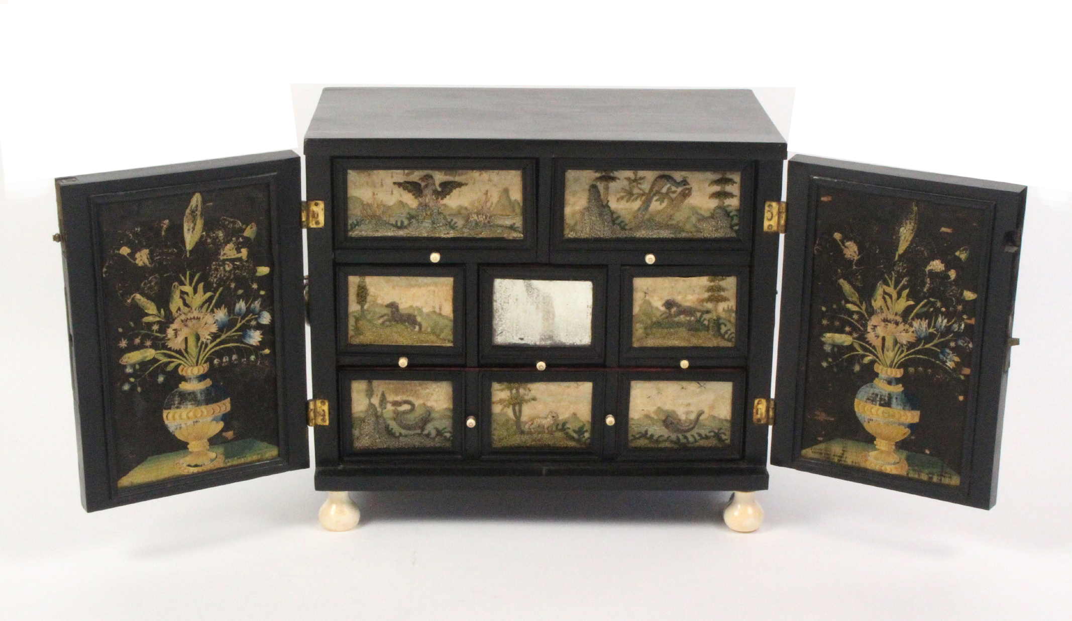 An Antwerp circa 1650 ebonised table cabinet embellished with needlework panels, the exterior