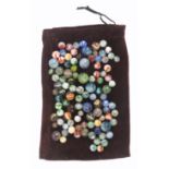 A collection of one hundred and one vintage glass marbles, in plum velvet bag. (102)