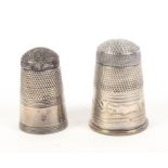 Two Georgian steel top silver thimbles, one with plain reeded edge frieze, one with leaf engraved