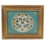 Buttons - a framed display of 23 buttons mostly 19th Century and comprising a set of six gilt