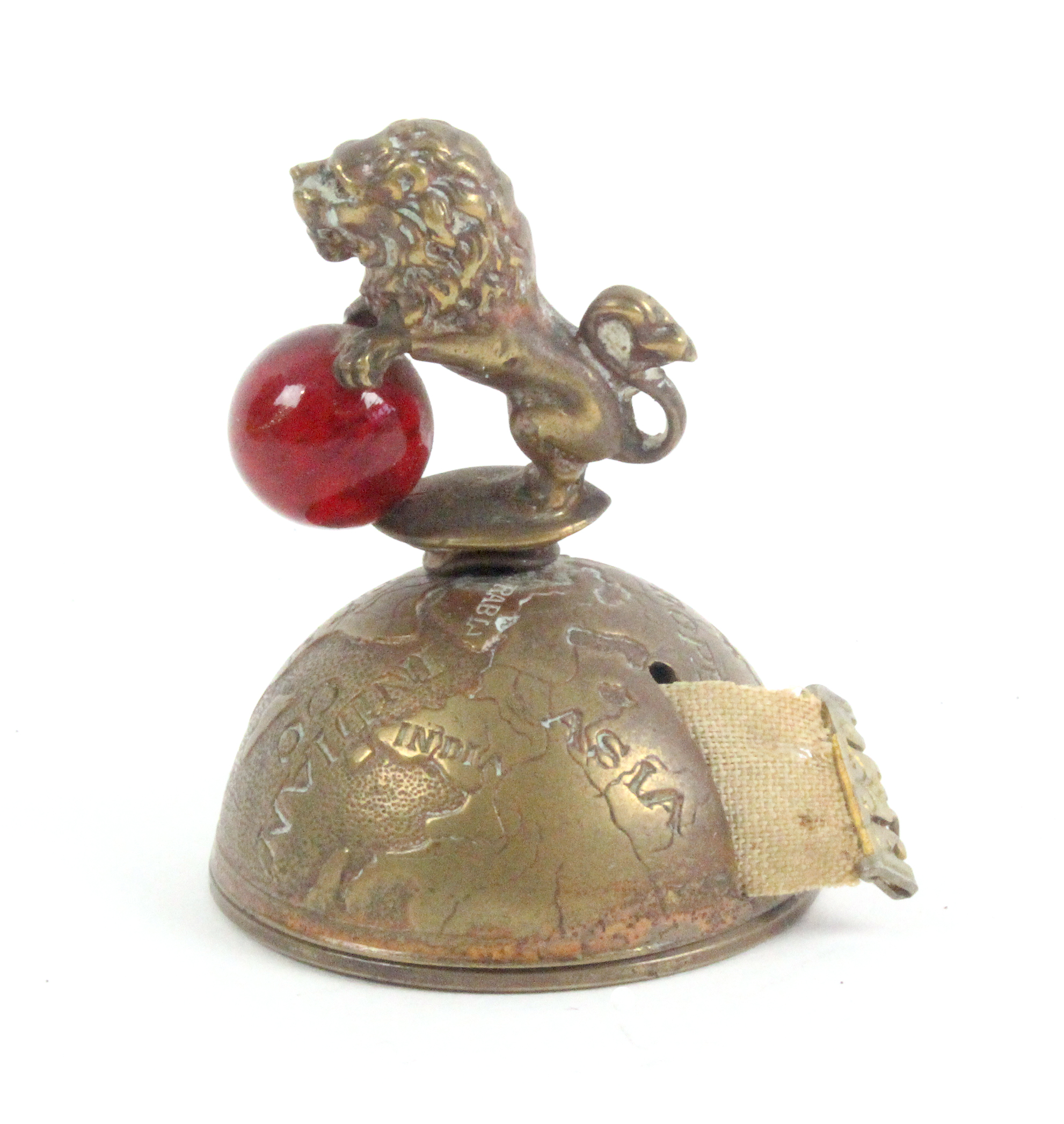 A novelty brass tape measure in the form of a half globe surmounted by a lion holding a glass