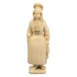 A mid 19th Century Dieppe carved ivory standing needle case, of a fisherwoman in traditional
