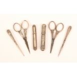 Six continental silver sewing tools, comprising a leaf decorated oval section needlecase, 6.8cm, a