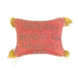 A documentary pin stuck pin cushion 1829, in red and yellow silk with tasselled corners, inscribed